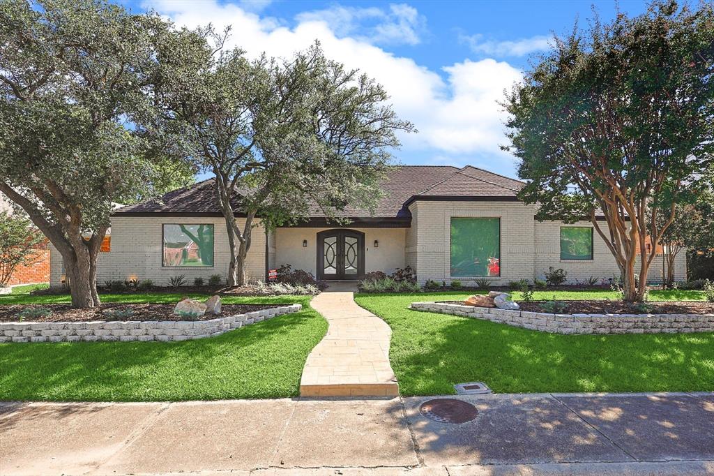 a front view of a house with a yard and trees