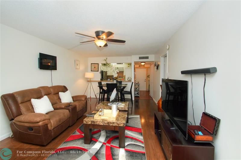 a living room with furniture a flat screen tv and a window