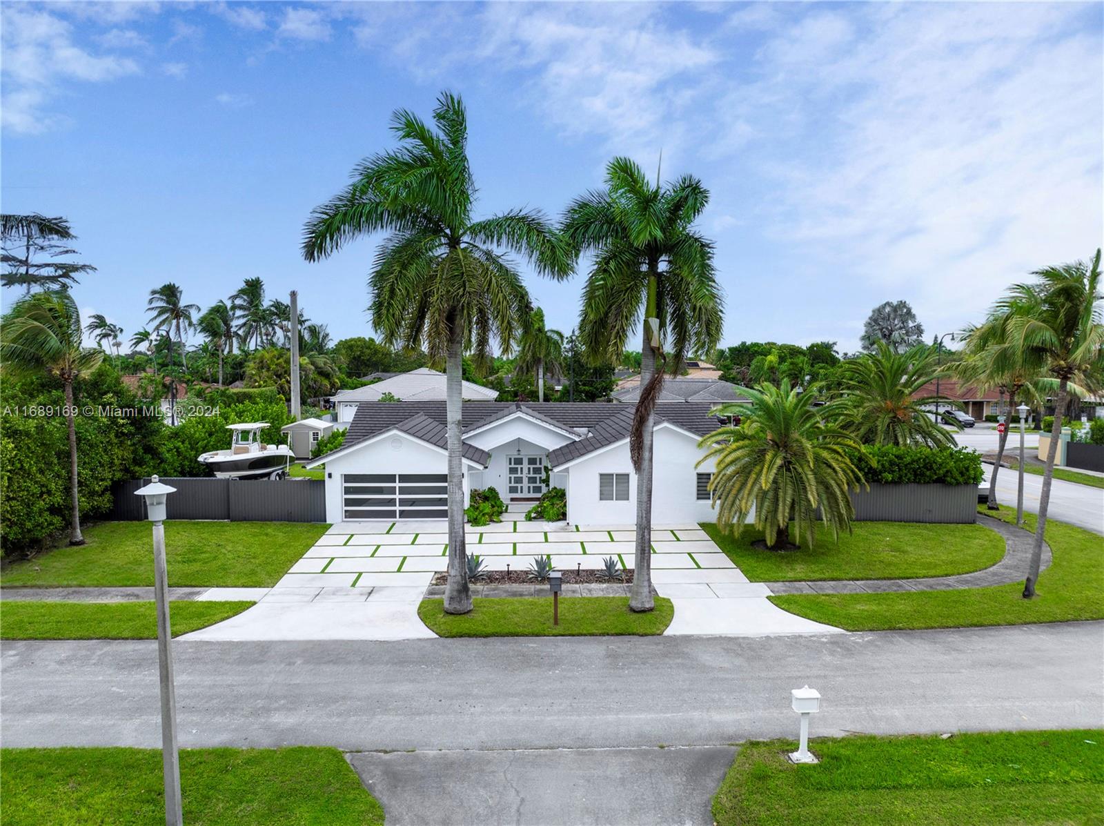 a front view of a house with garden and trees