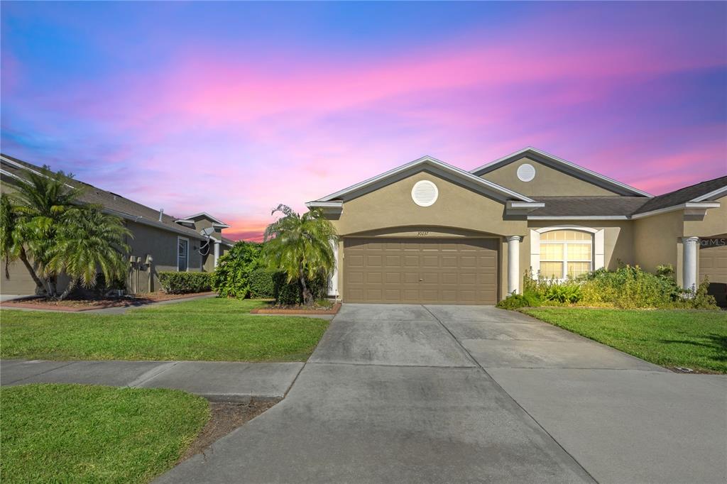 a front view of a house with a yard and garage