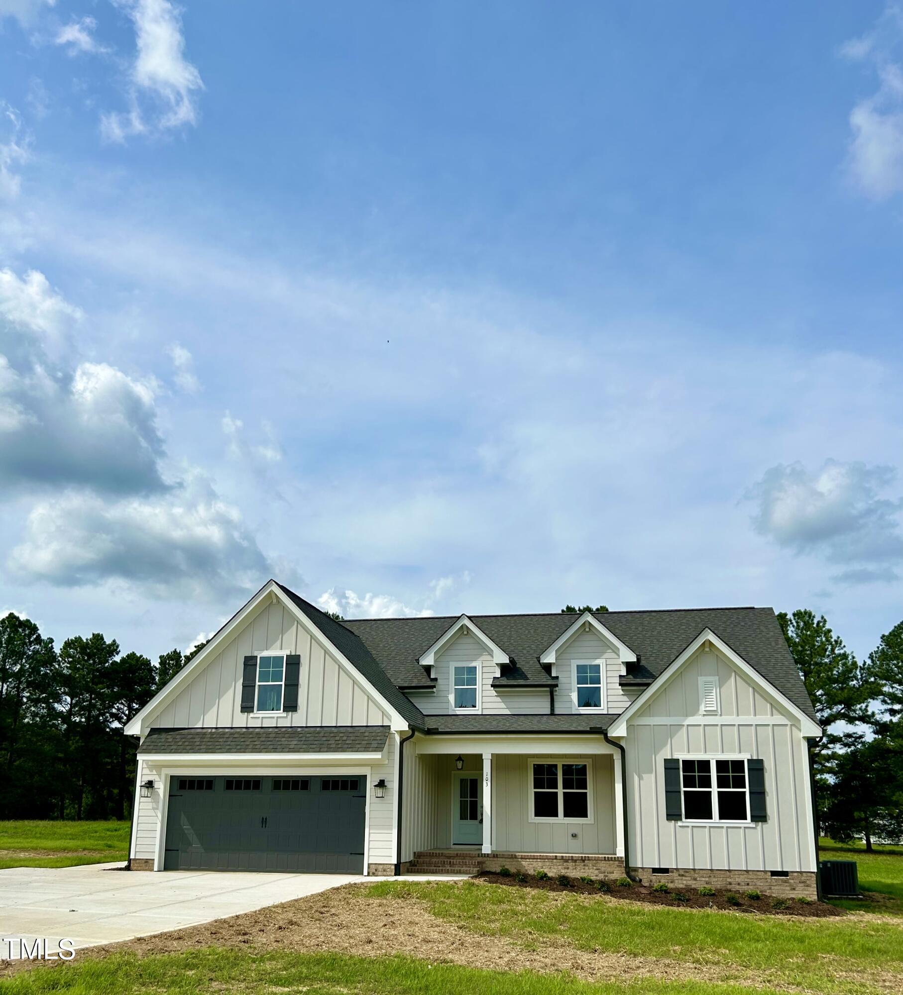 a front view of a house with a garden and yard