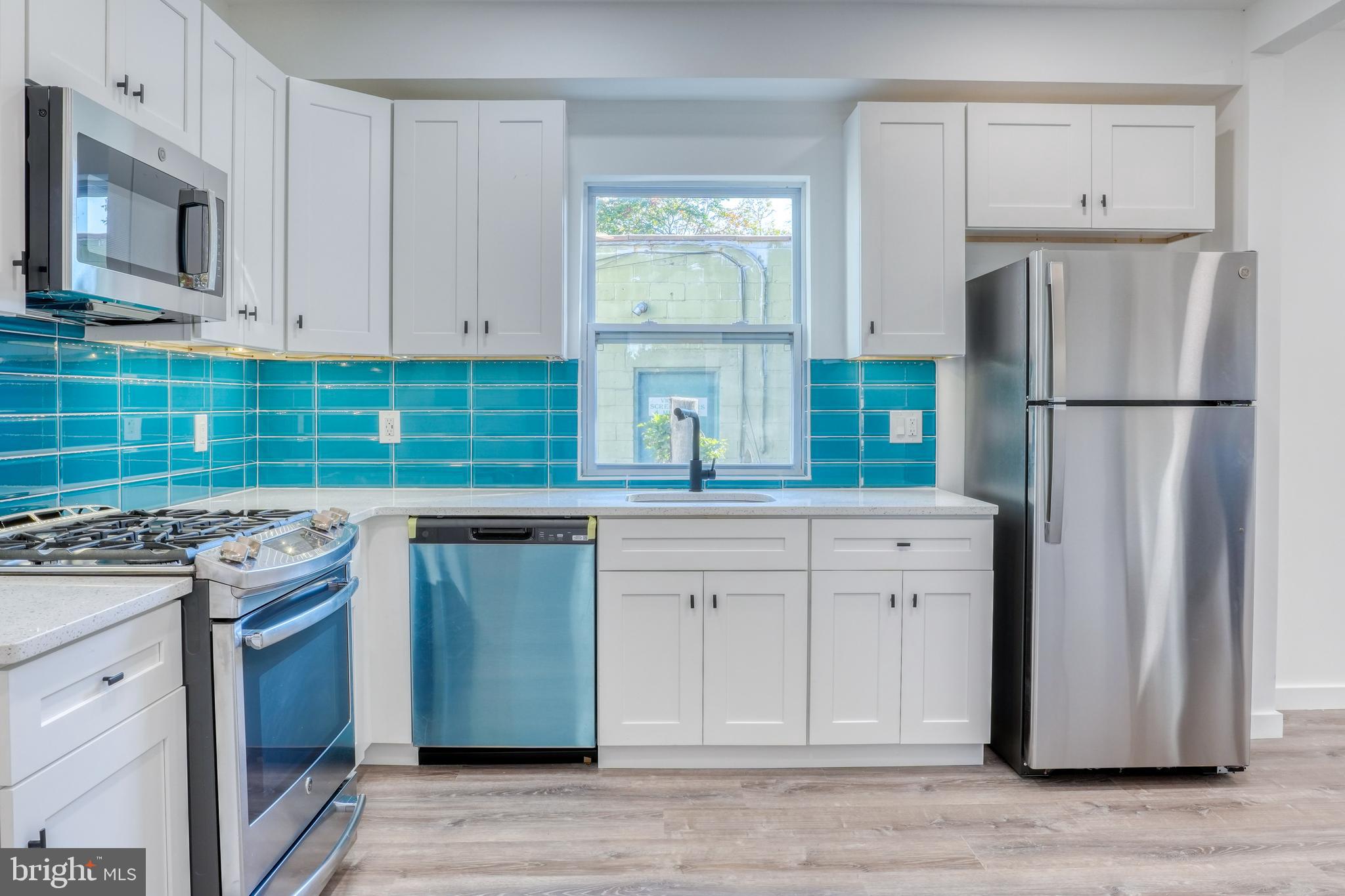 a kitchen with stainless steel appliances granite countertop a refrigerator sink and stove