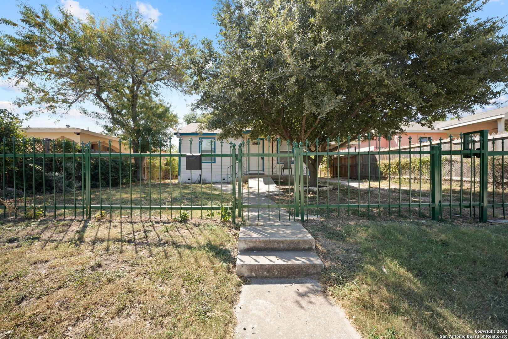 a view of a house with backyard and a tree