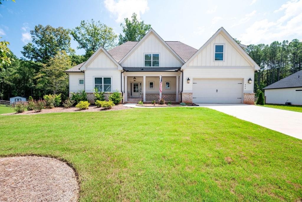 a front view of a house with a yard and trees