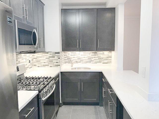 a kitchen with a sink stove and cabinets