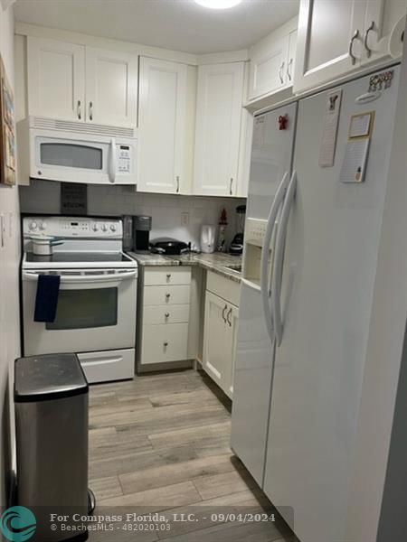 a kitchen with white cabinets and white appliances