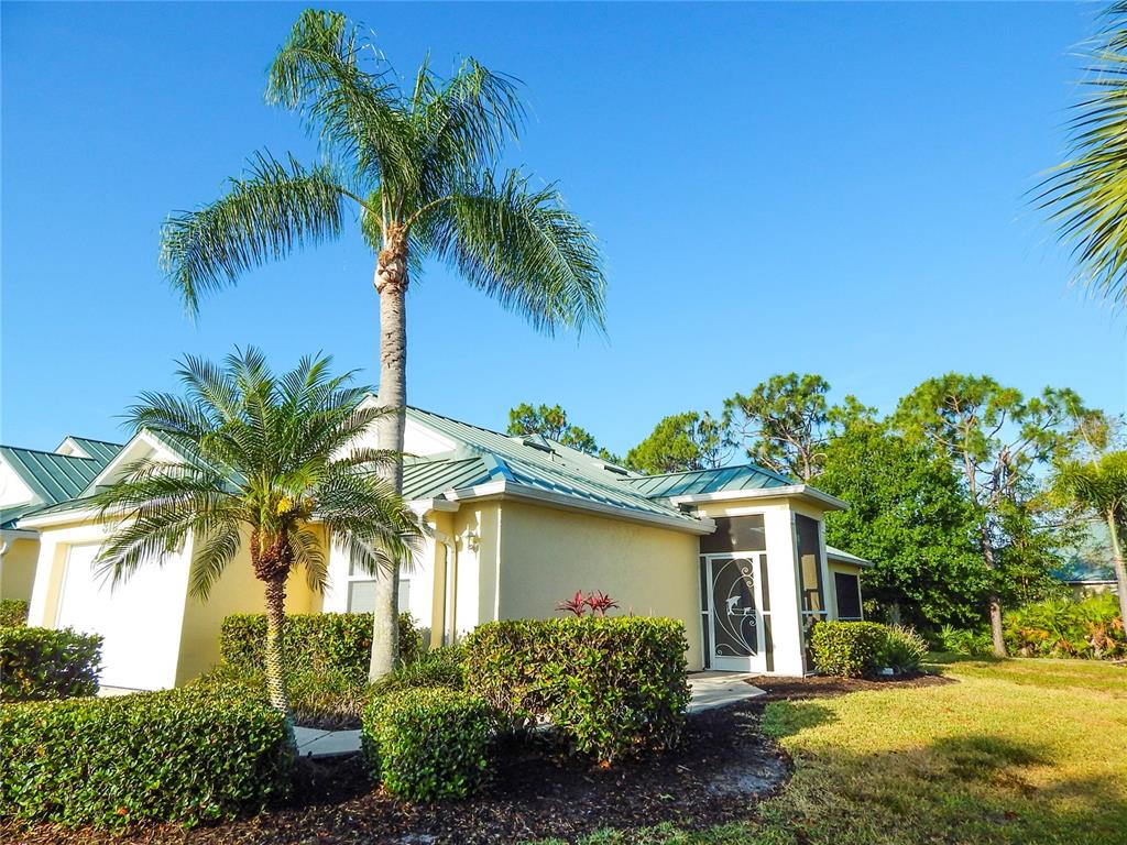 a view of a house with a yard and palm trees