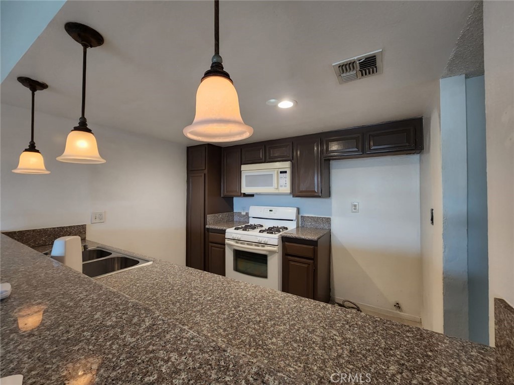 a kitchen with stainless steel appliances granite countertop a sink a stove and a refrigerator