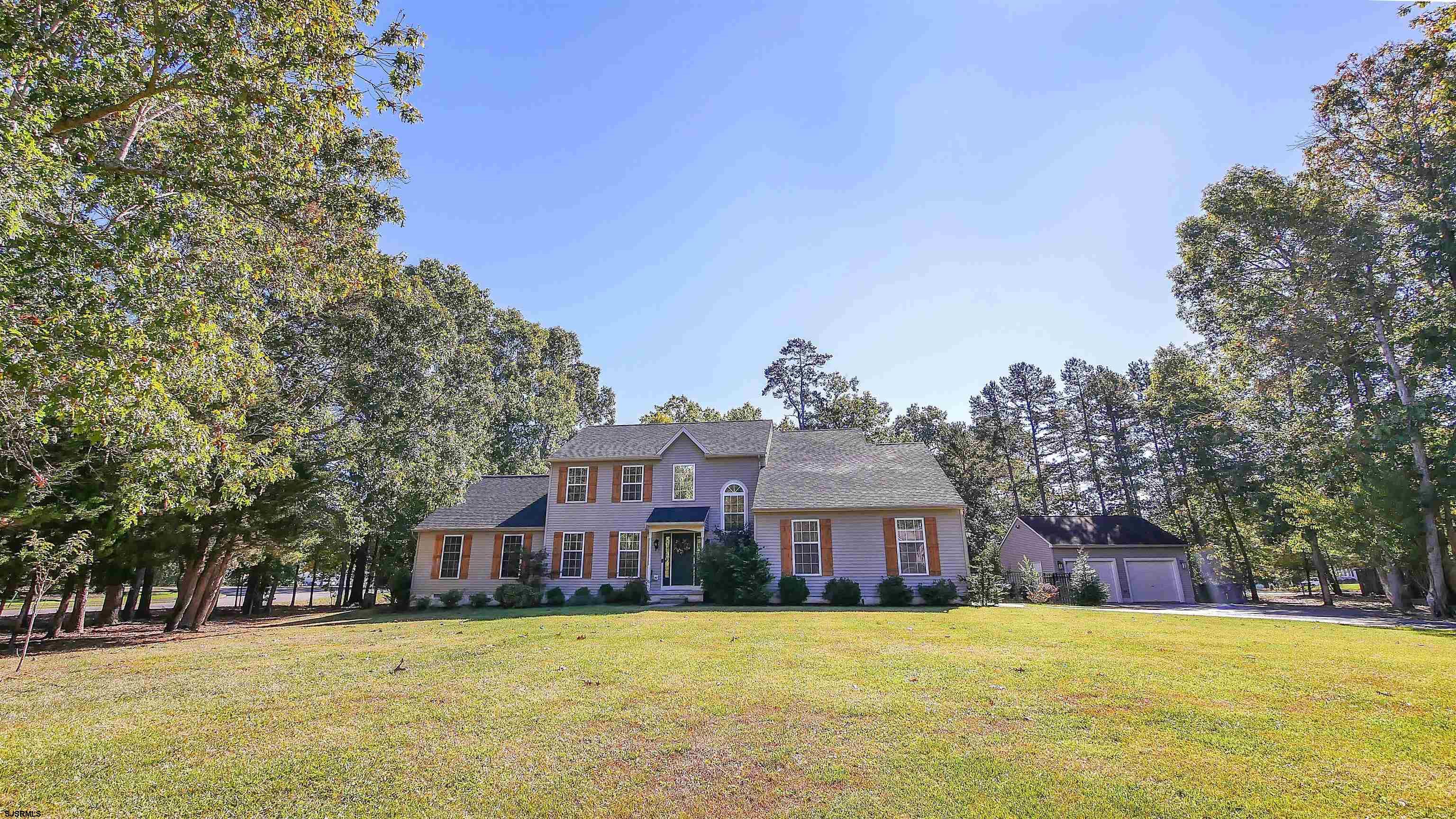 a front view of a house with a yard and trees