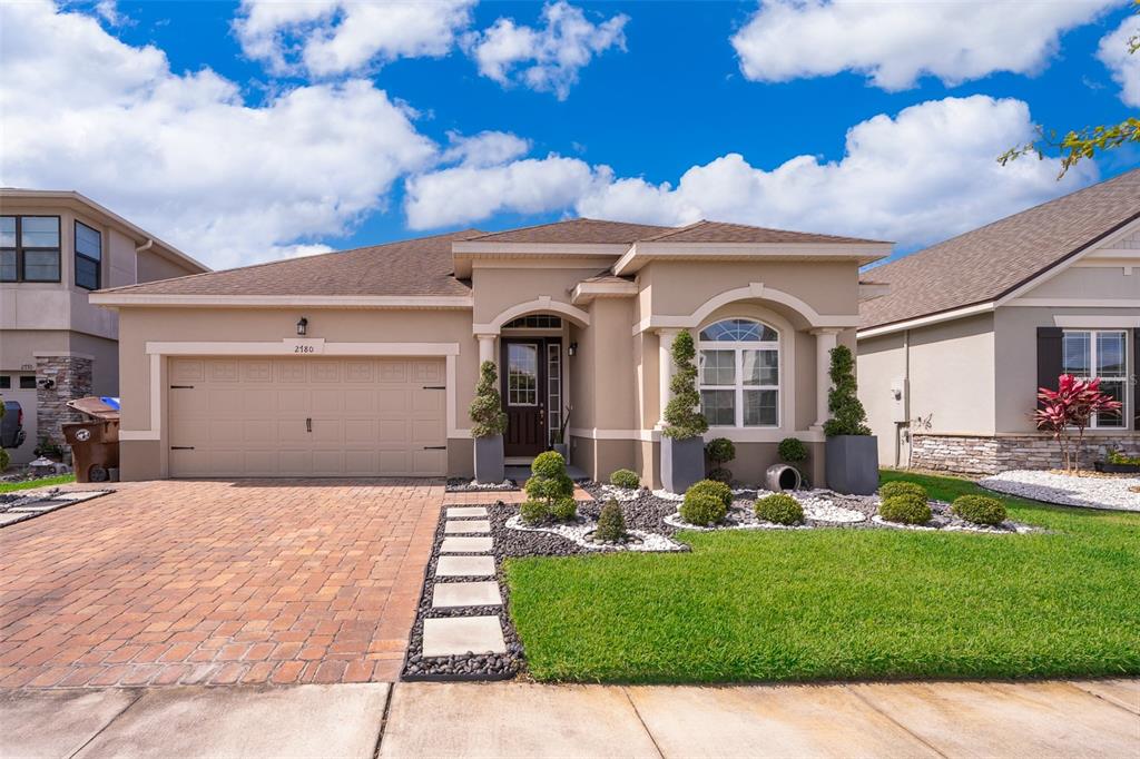 a front view of a house with a garden and yard