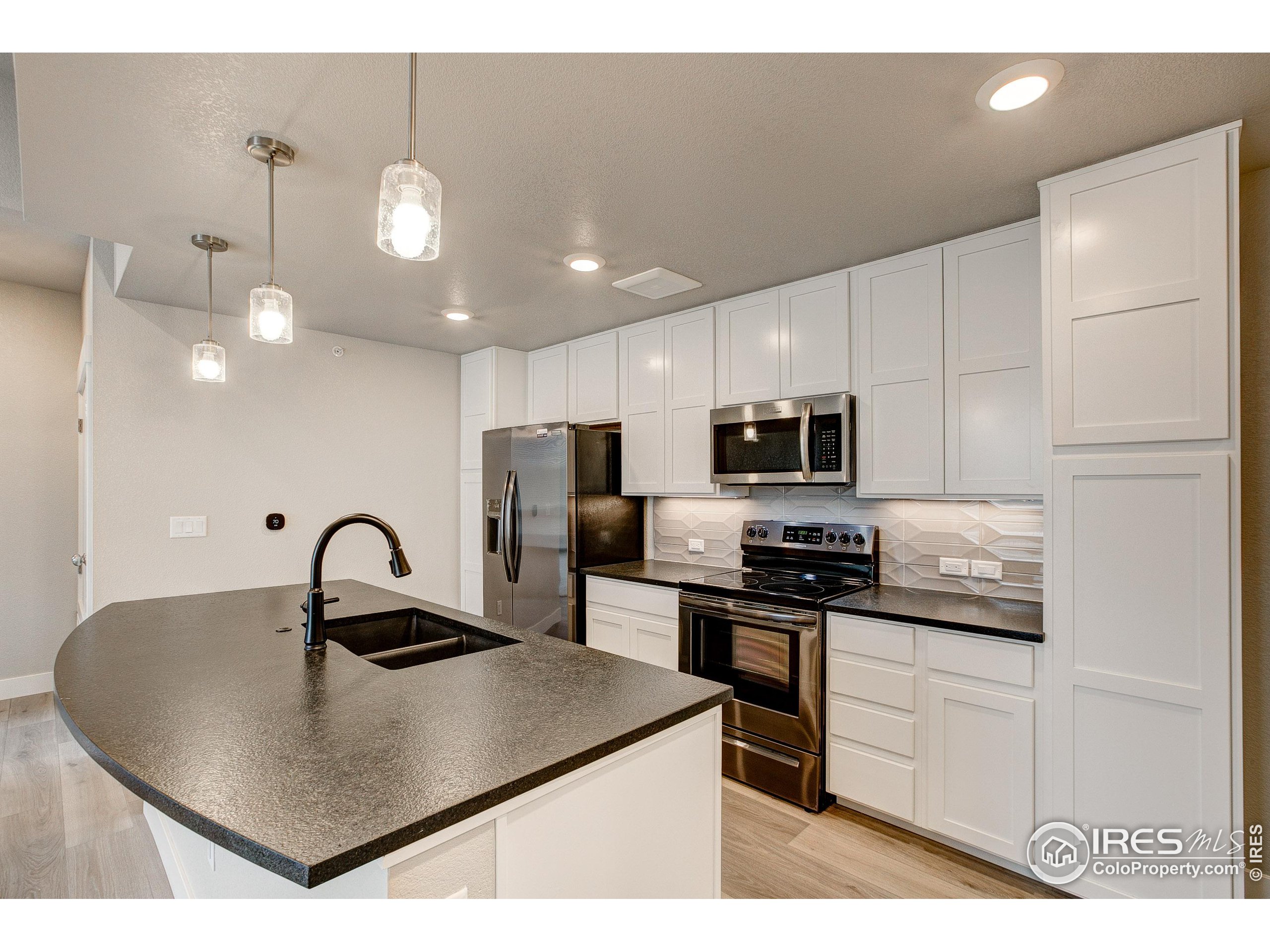 a kitchen with kitchen island a sink table and chairs