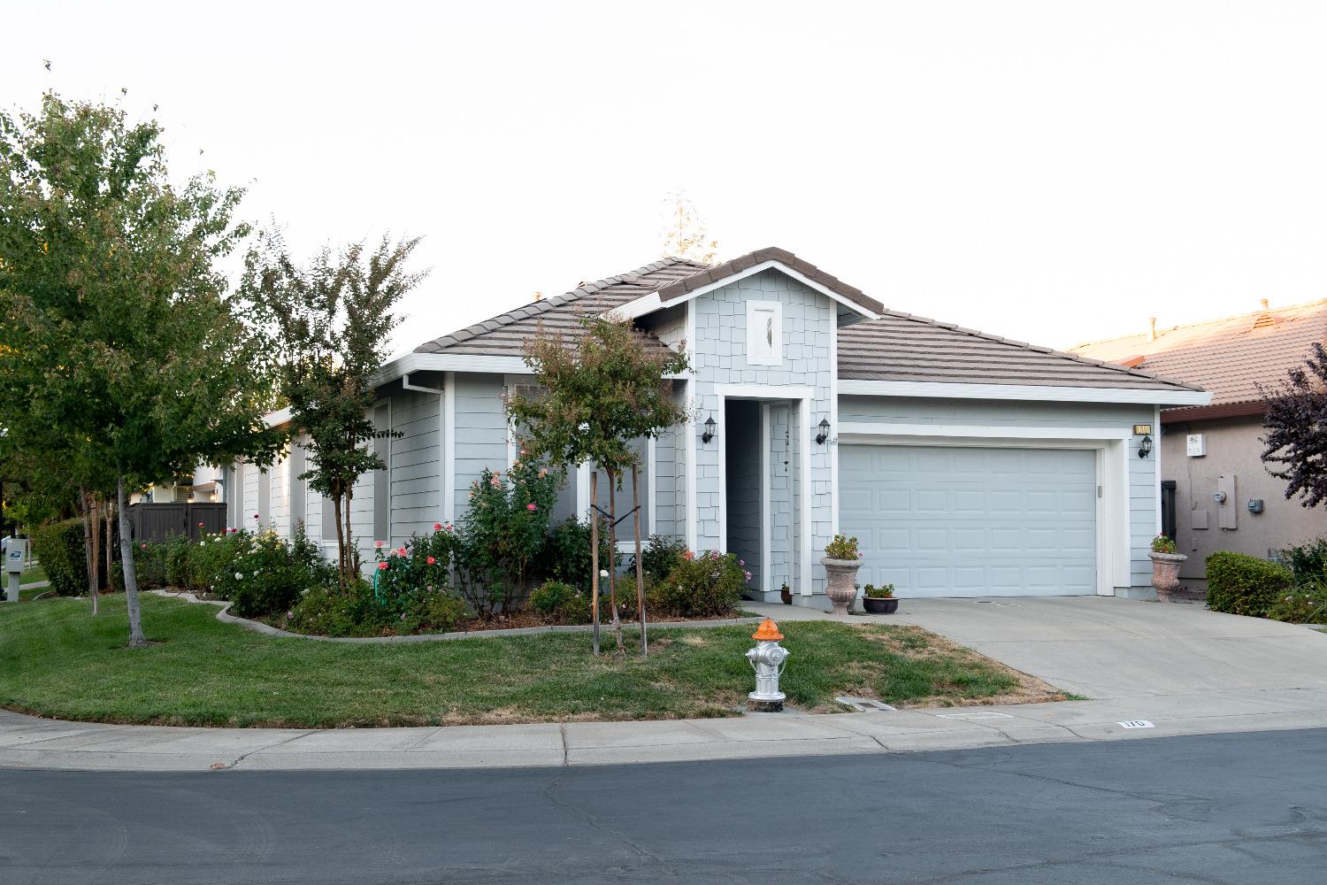 a front view of a house with a yard and potted plants