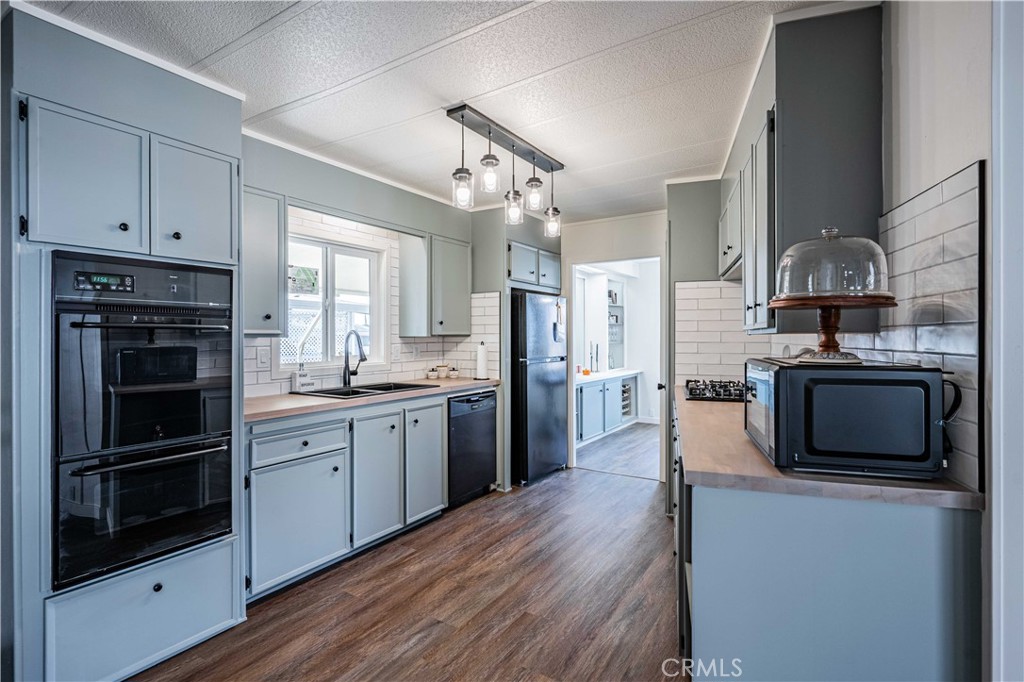 a kitchen with stainless steel appliances a stove sink microwave and cabinets