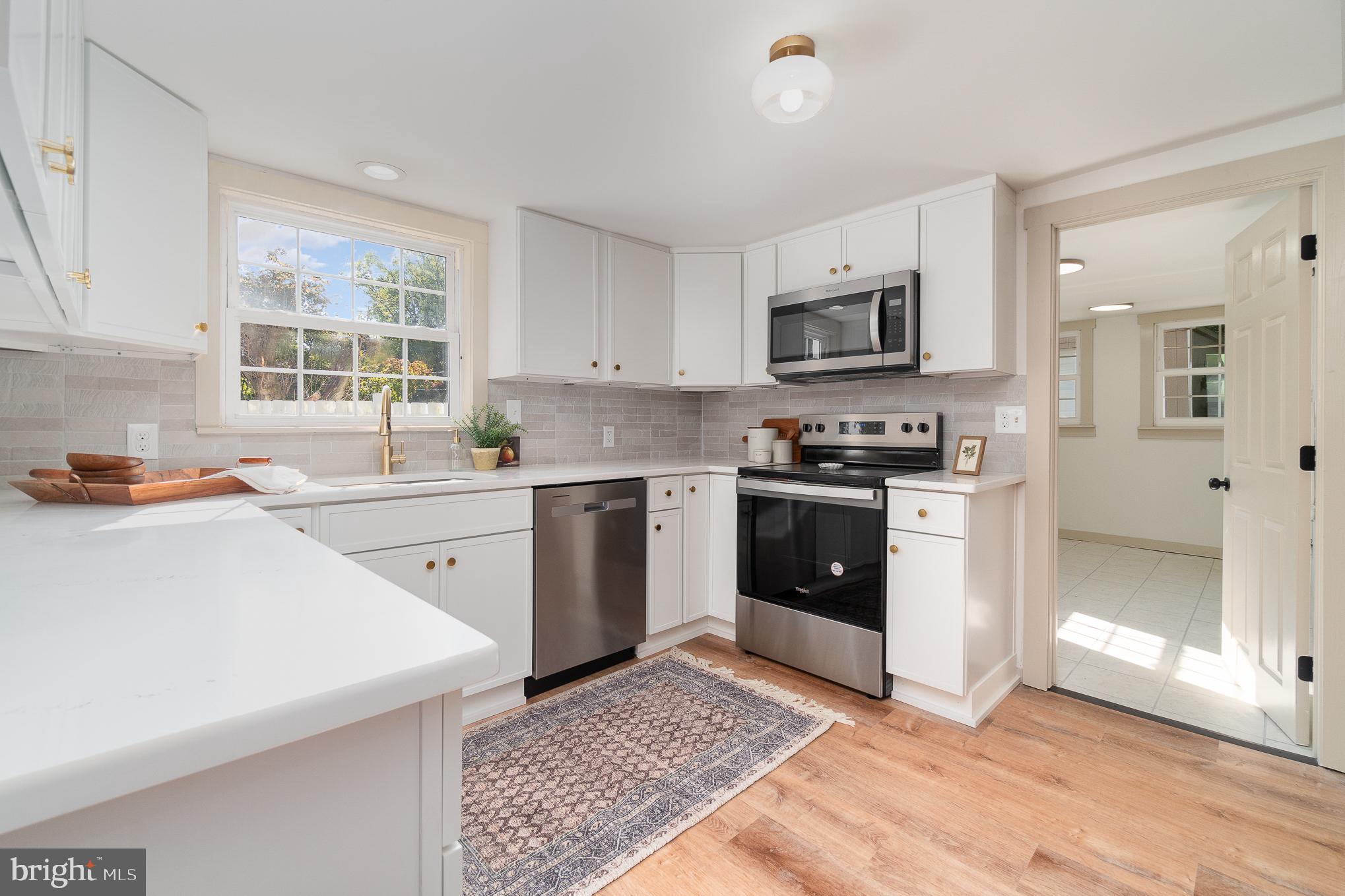 a kitchen with stainless steel appliances a stove sink microwave and cabinets