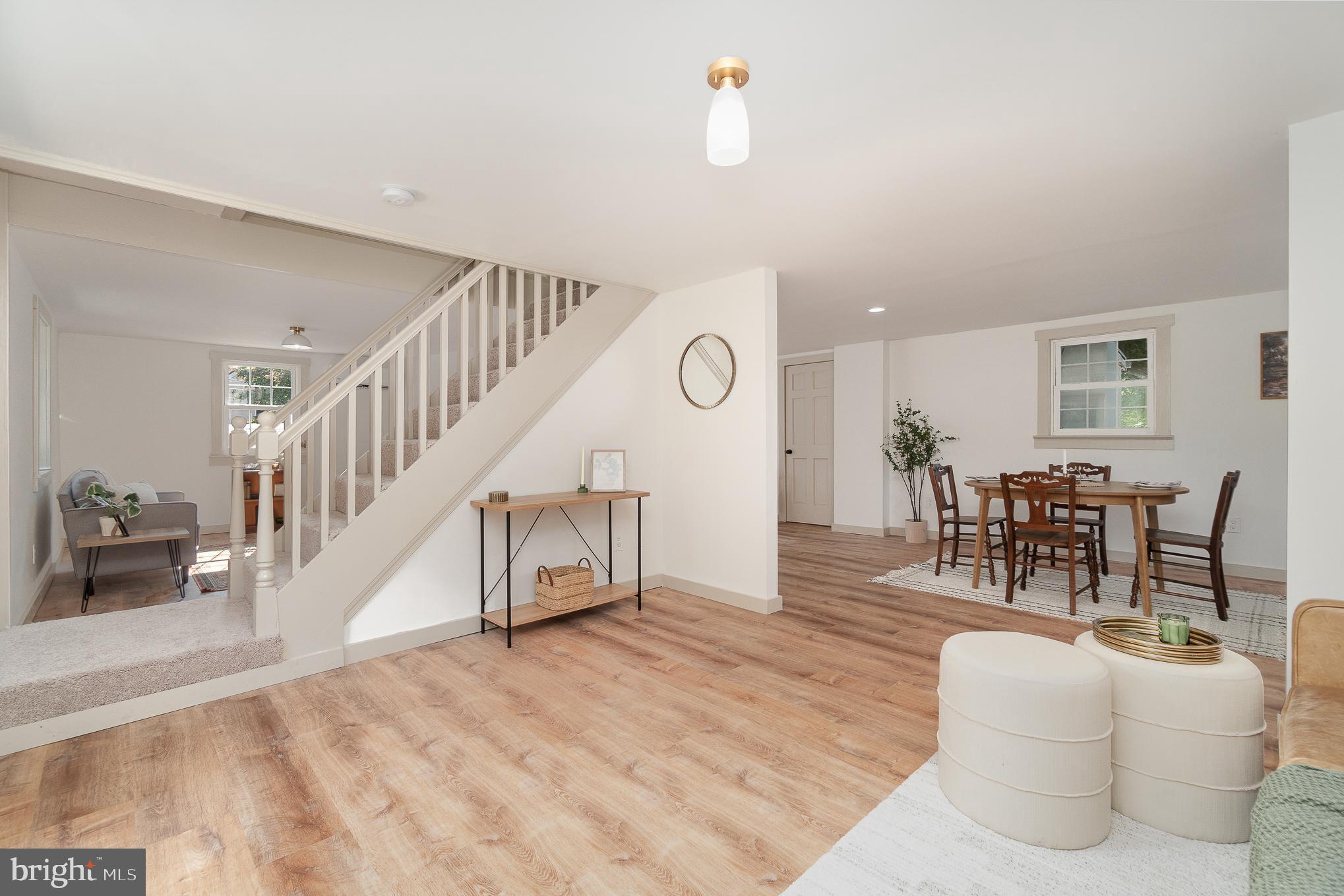 a living room with furniture and a dining table with wooden floor