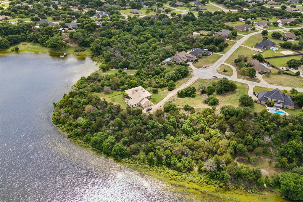 an aerial view of residential house with outdoor space and trees all around