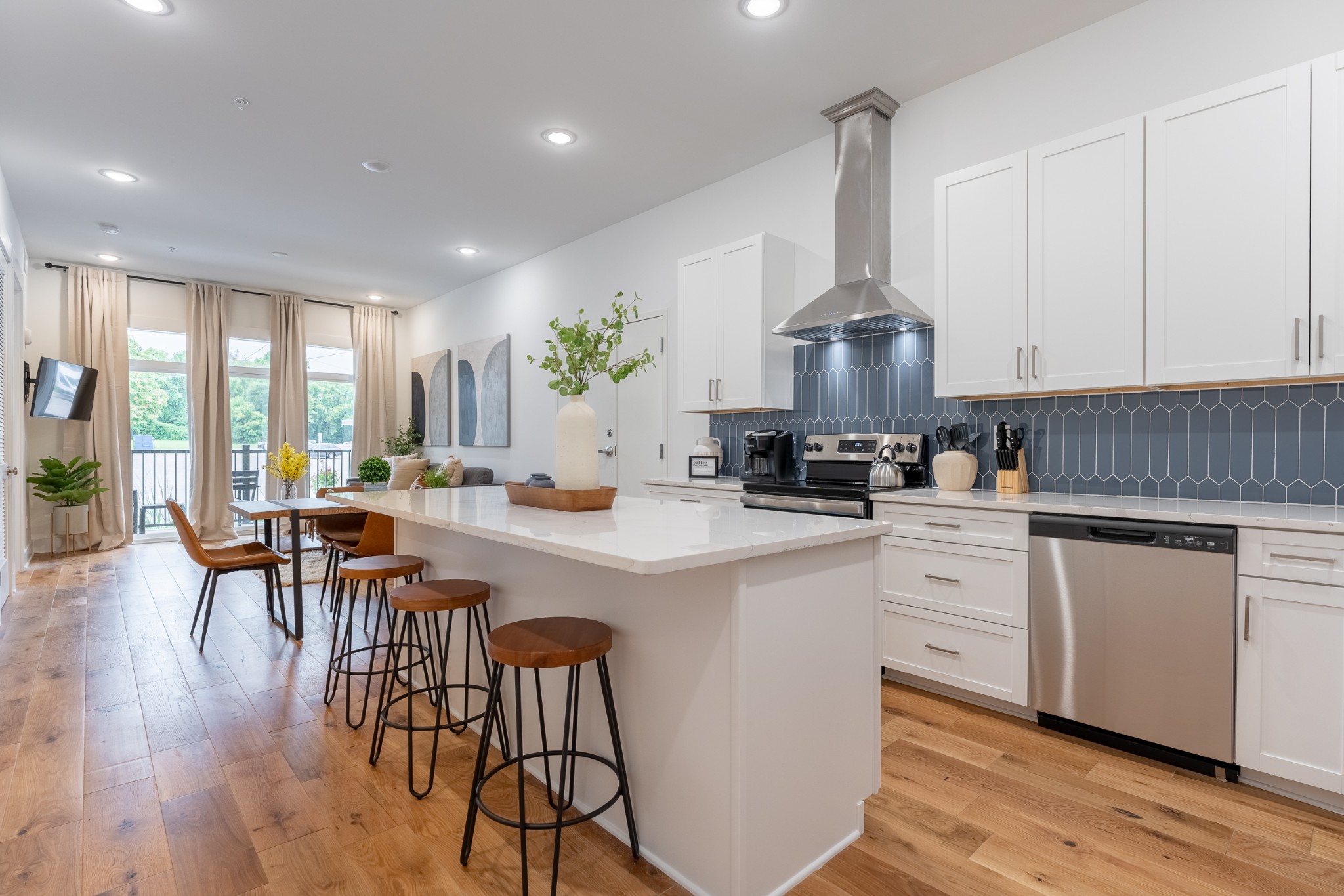 a kitchen with stainless steel appliances a dining table chairs stove and cabinets