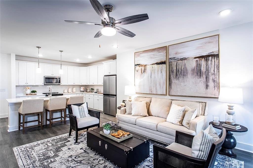 a living room with stainless steel appliances kitchen island furniture and a table