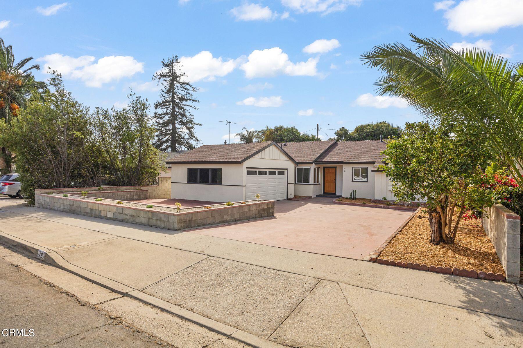 a front view of a house with a yard and trees