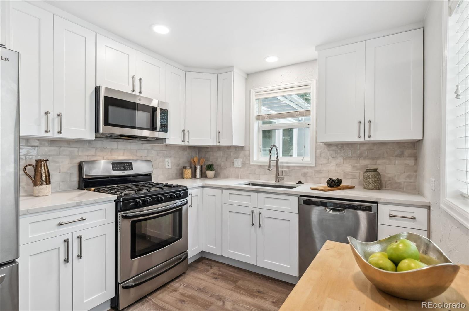 a kitchen with stainless steel appliances a stove a sink a microwave and cabinets