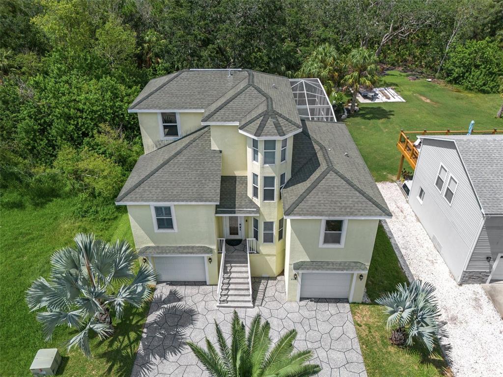 a aerial view of a house next to a yard with big trees