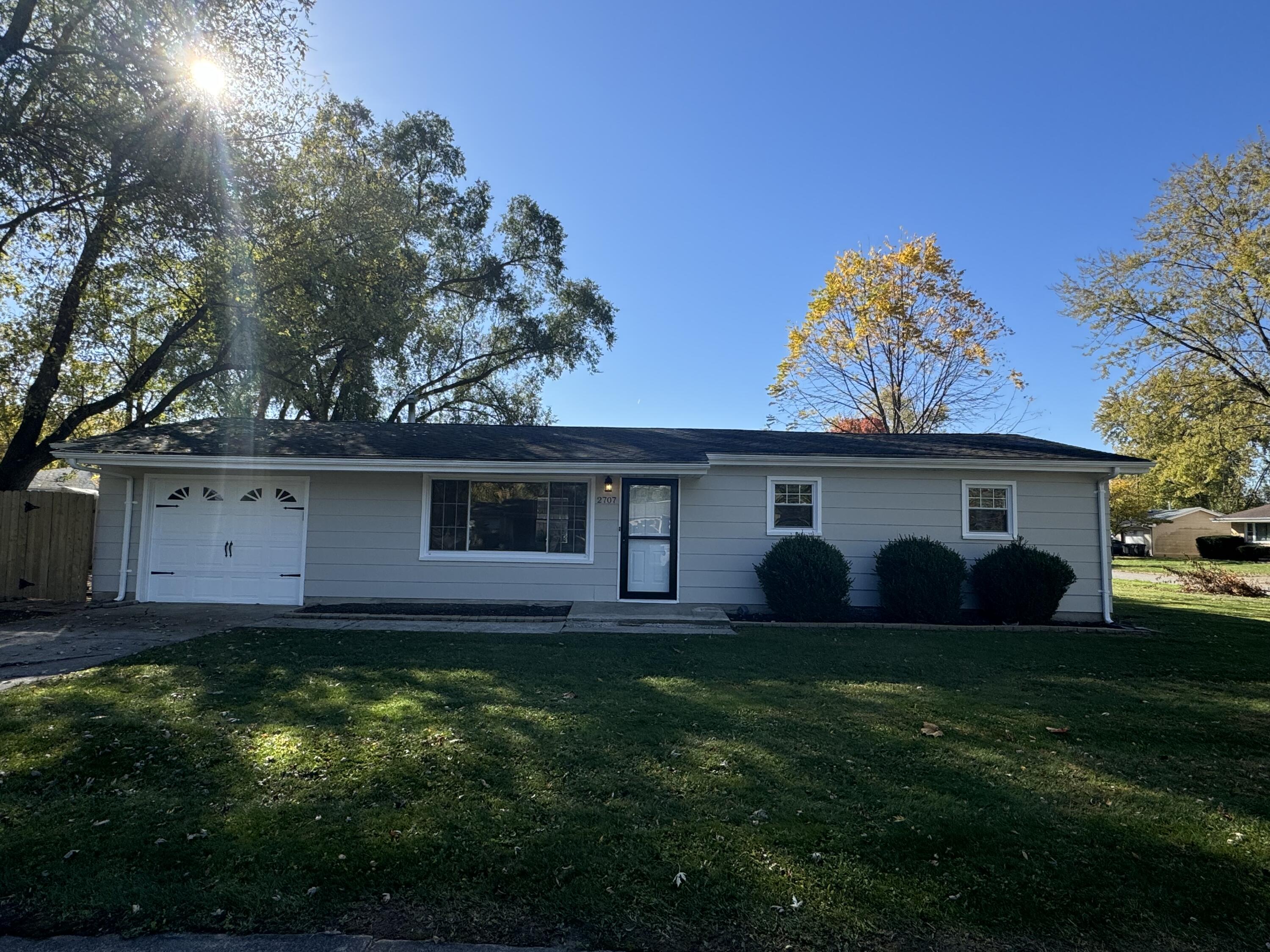 a view of a house with a yard and a large tree