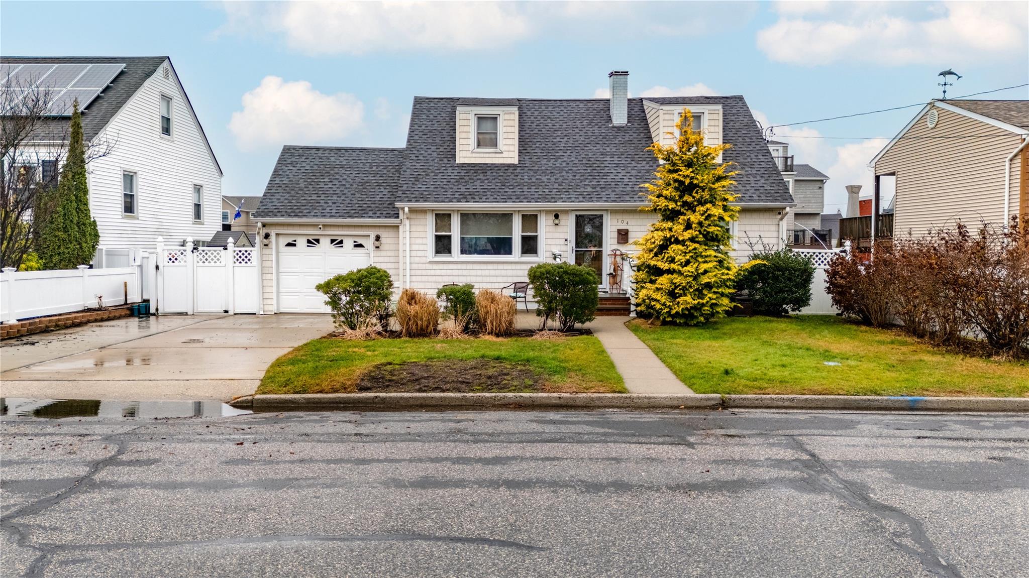 Cape cod home with a garage and a front lawn