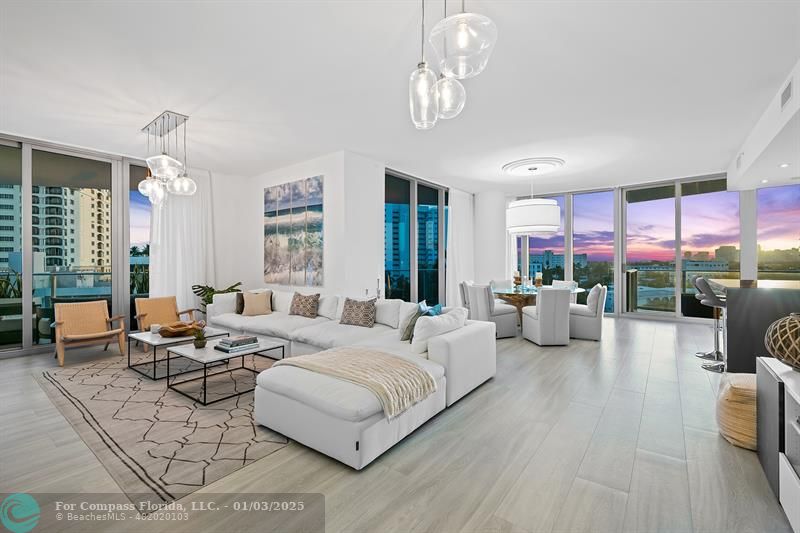 a living room with patio furniture and a chandelier