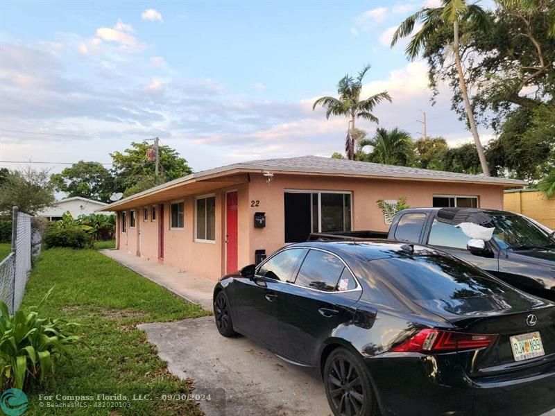 a car parked in front of a house with potted plants