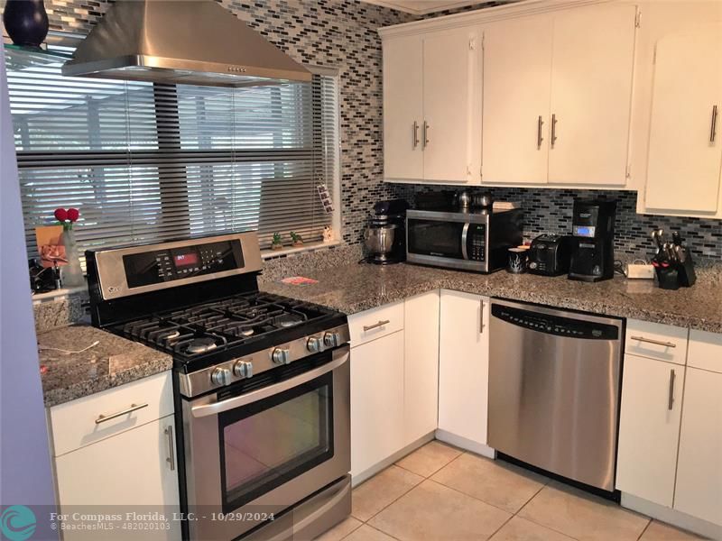 a kitchen with granite countertop a stove and a sink