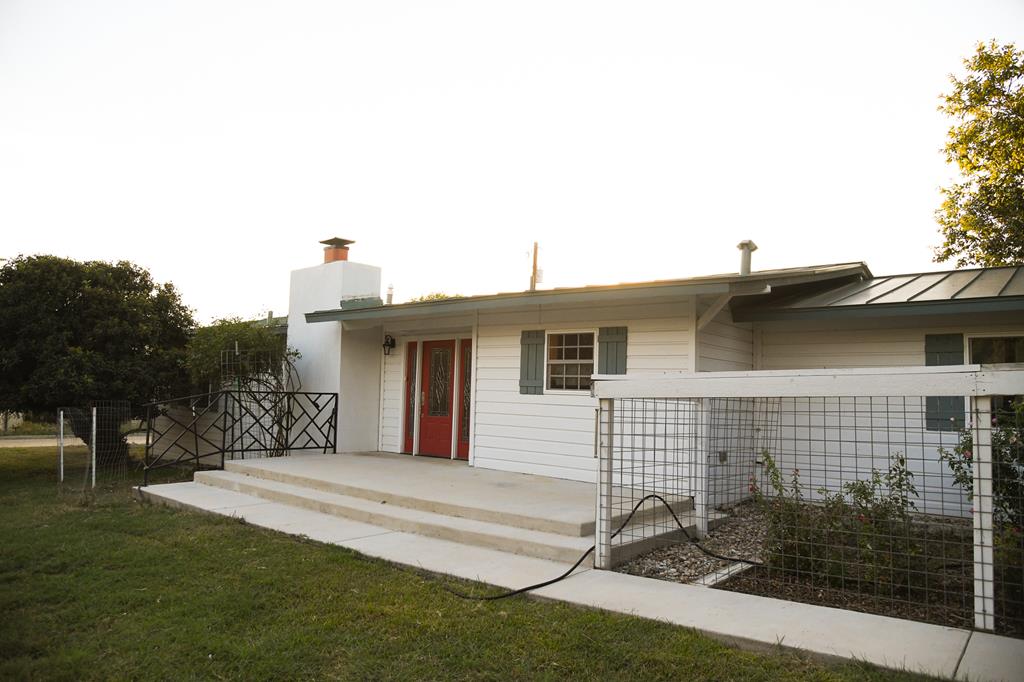 a backyard of a house with table and chairs