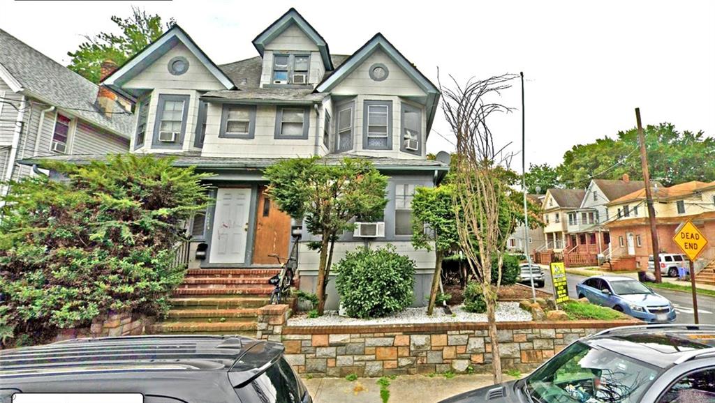 a front view of a house with a yard and potted plants