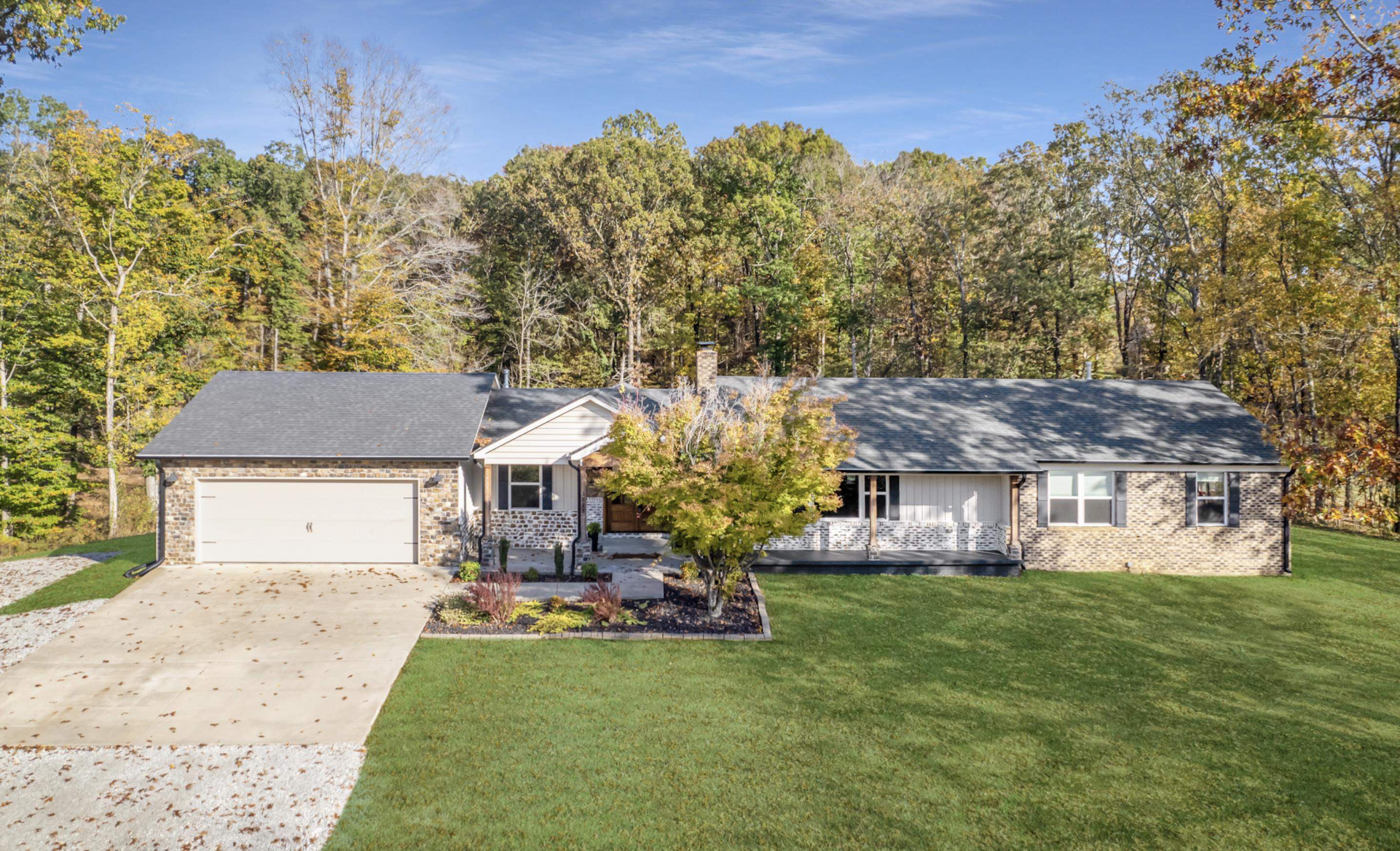 Ranch-style house with a garage and a front lawn