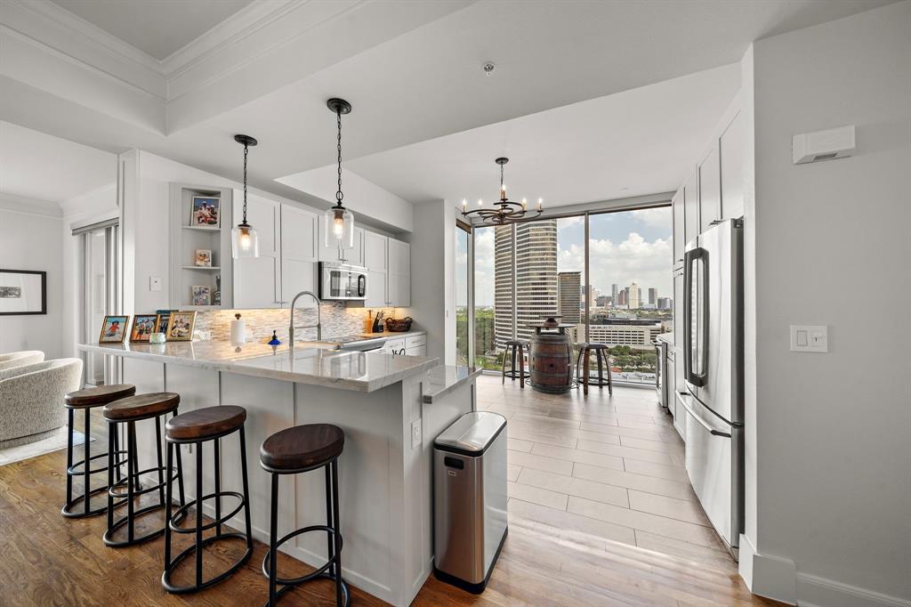 a kitchen with kitchen island granite countertop a table chairs stove and wooden floor