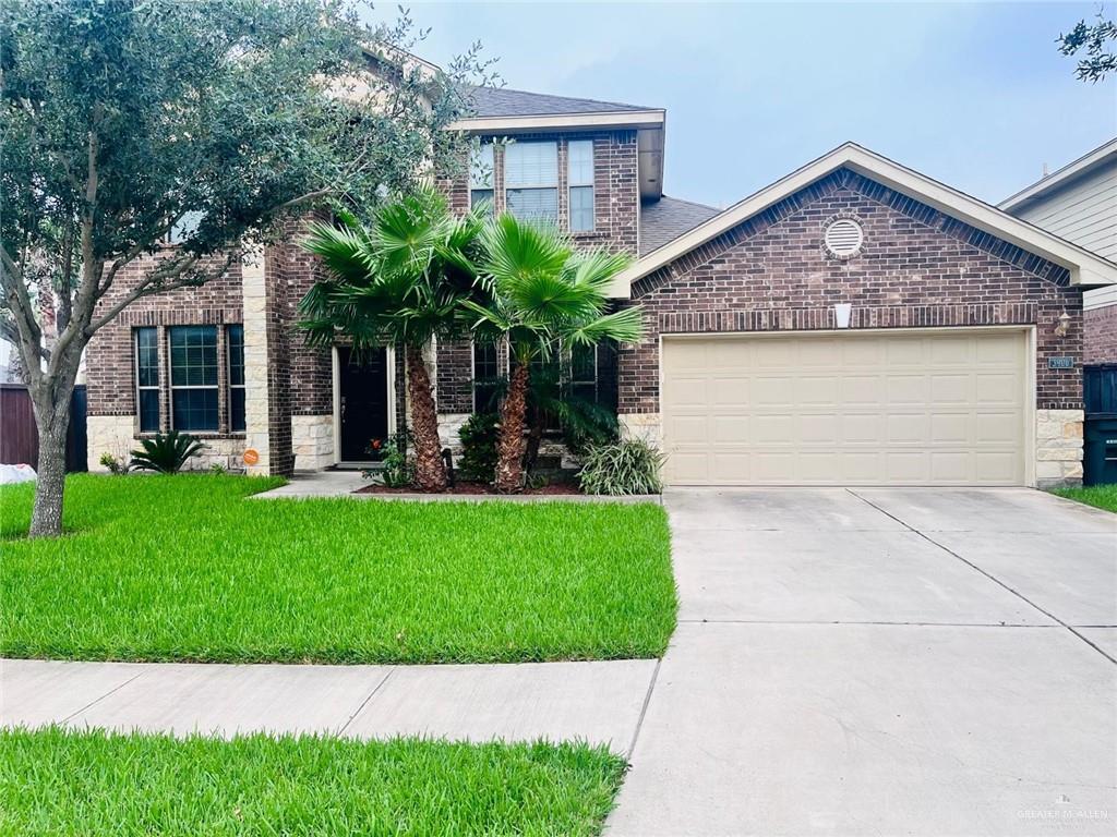 View of front of home with a front lawn and a garage