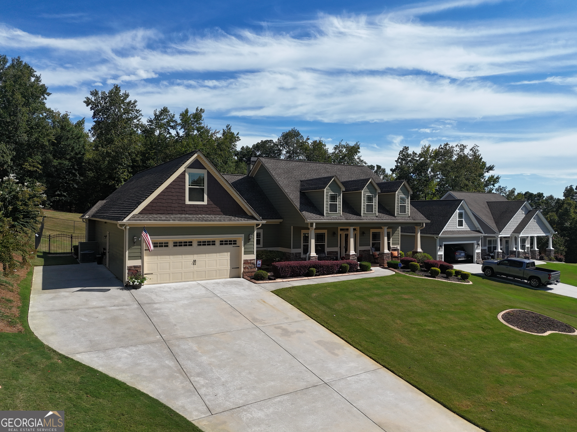 a view of a house with a big yard plants and large trees