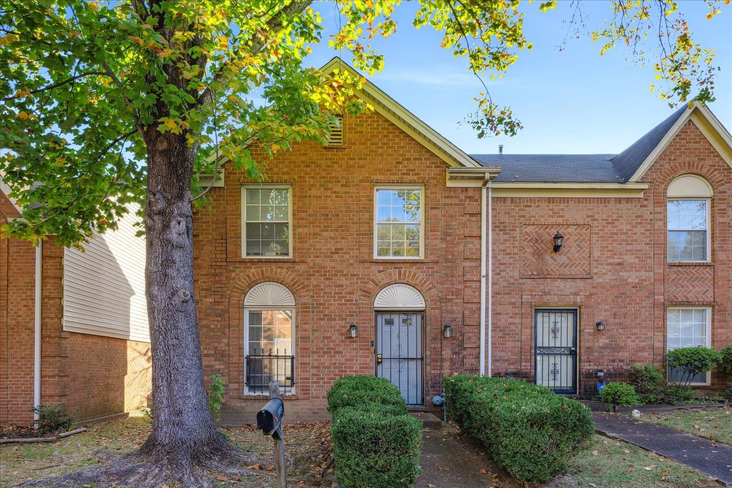 a front view of a house with a tree