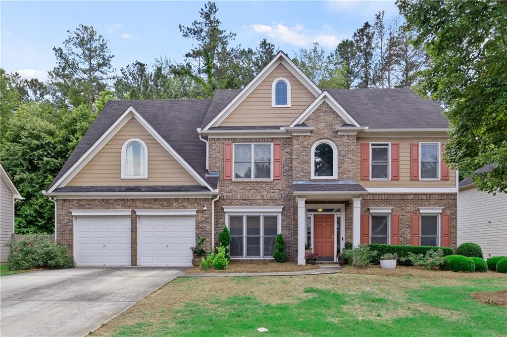 a front view of a house with a yard and garage