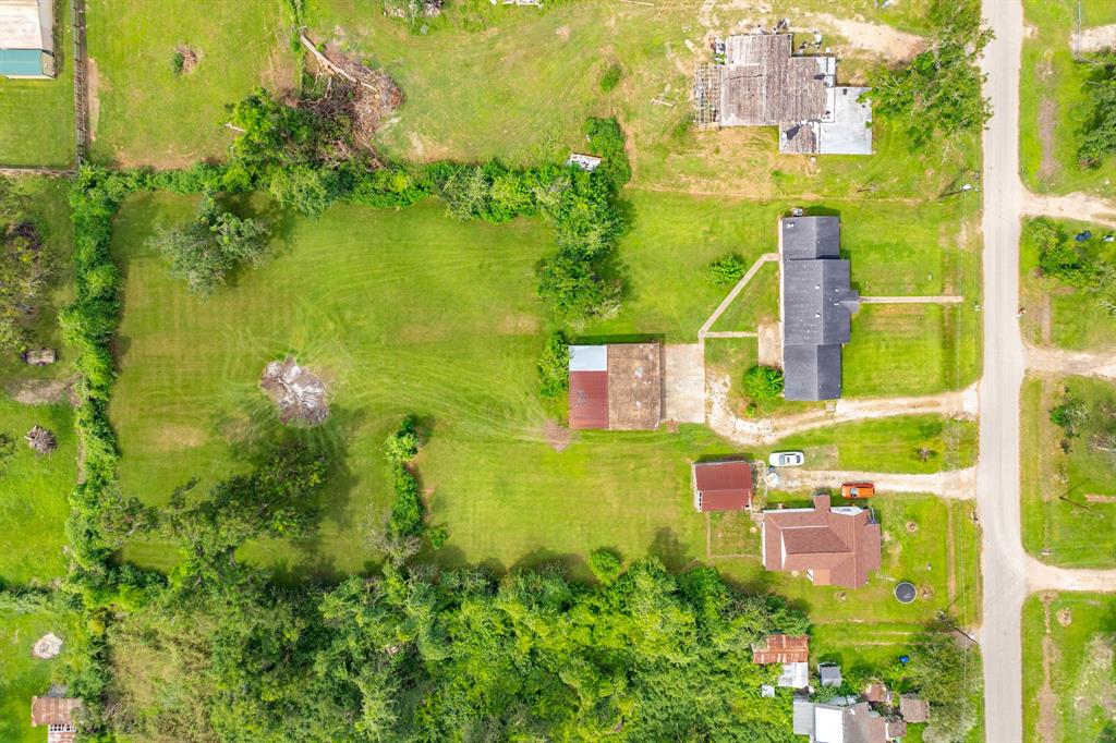 an aerial view of residential houses with outdoor space and trees all around