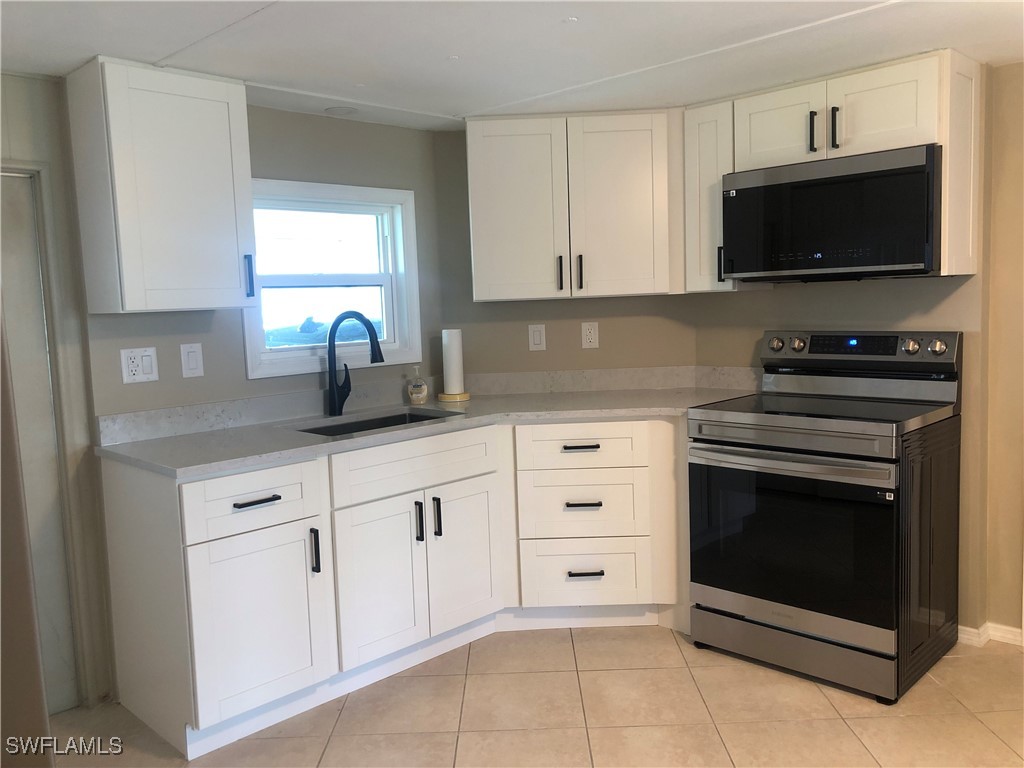 a kitchen with white cabinets and appliances