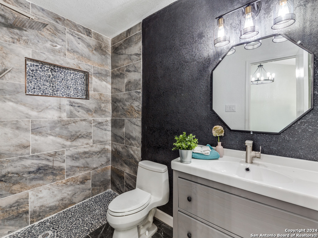 a bathroom with a sink mirror and toilet