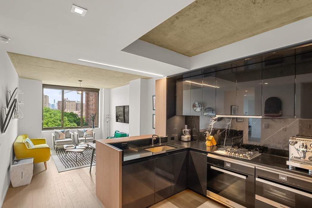 a kitchen with a stove and a view of living room