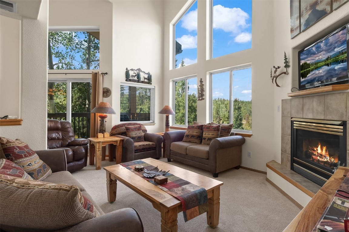 a living room with furniture a large window and a fireplace