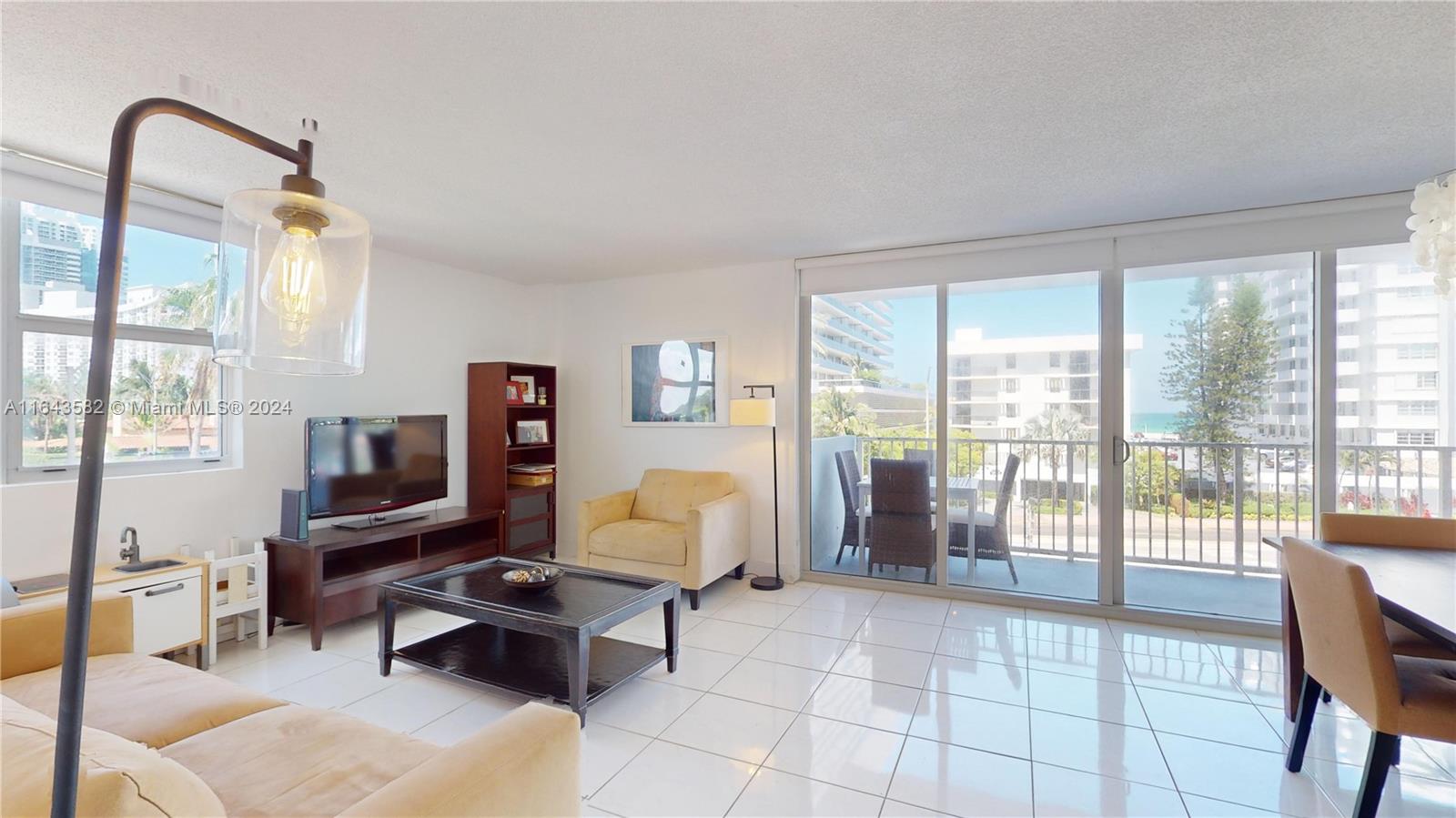 a living room with furniture a flat screen tv and a floor to ceiling window