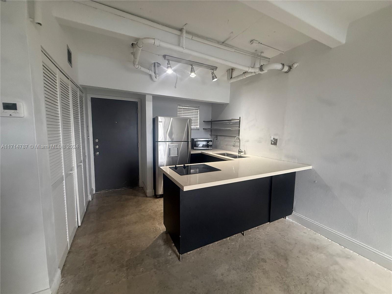 a kitchen with stainless steel appliances granite countertop a sink and a refrigerator