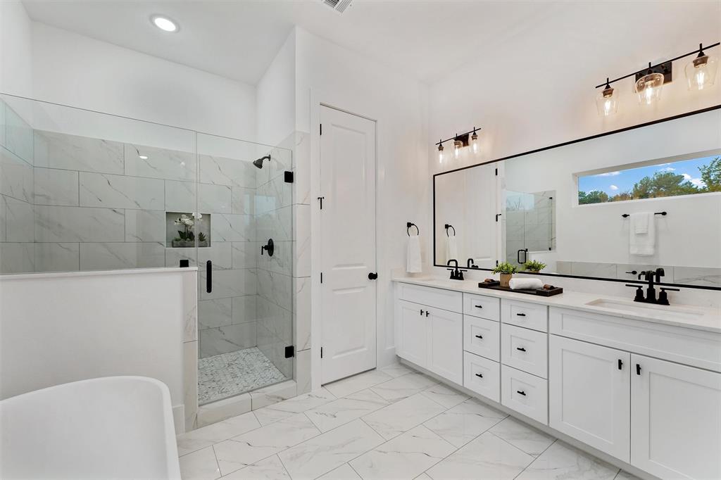 a bathroom with a double vanity sink toilet and shower