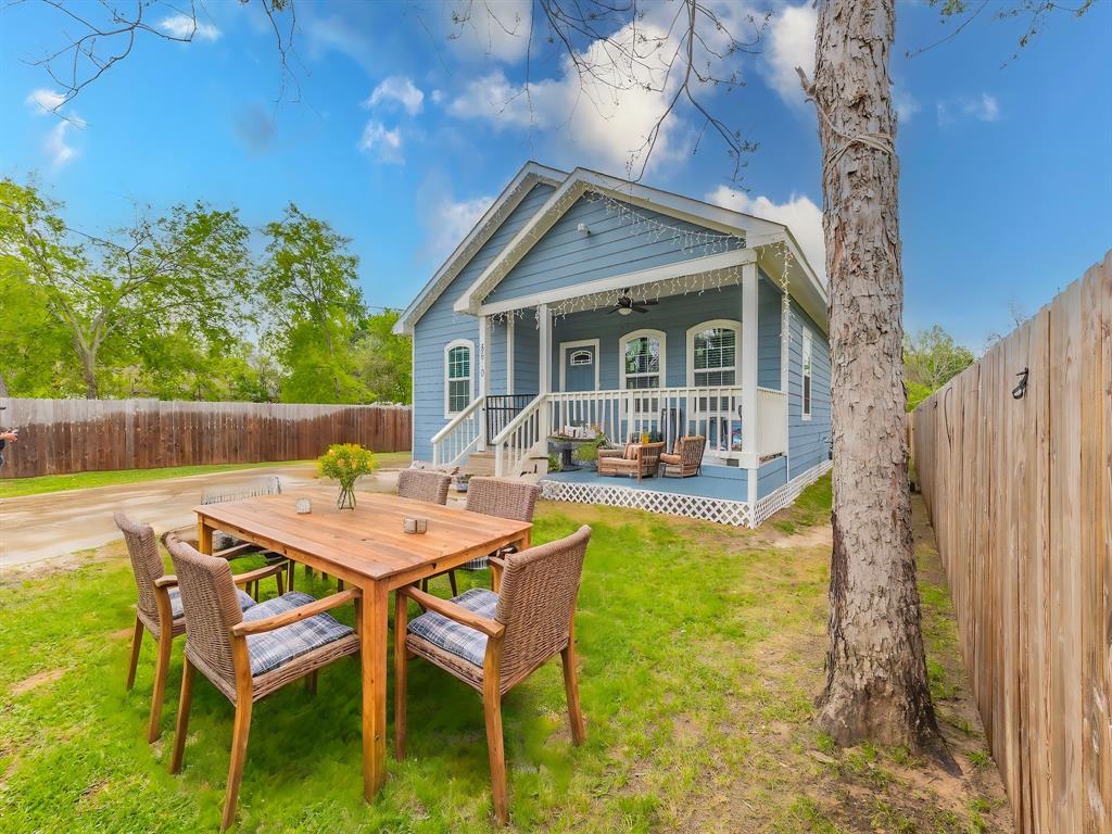 a view of a patio with table and chairs with wooden floor and fence