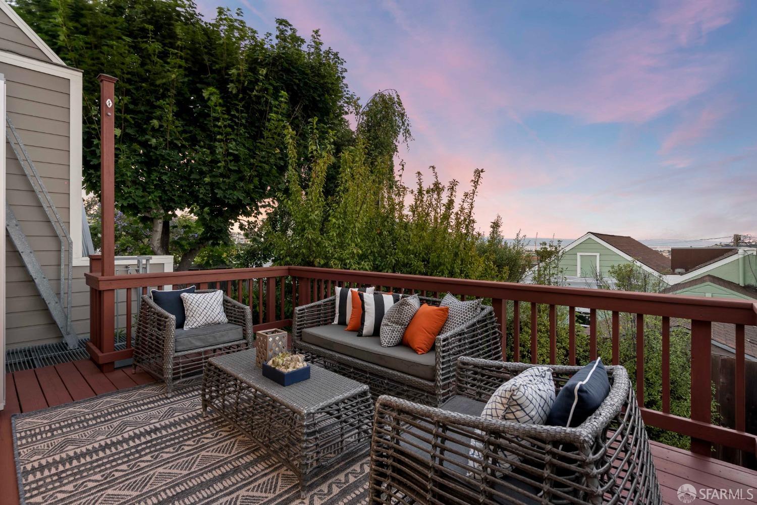 a roof deck with couches and wooden floor