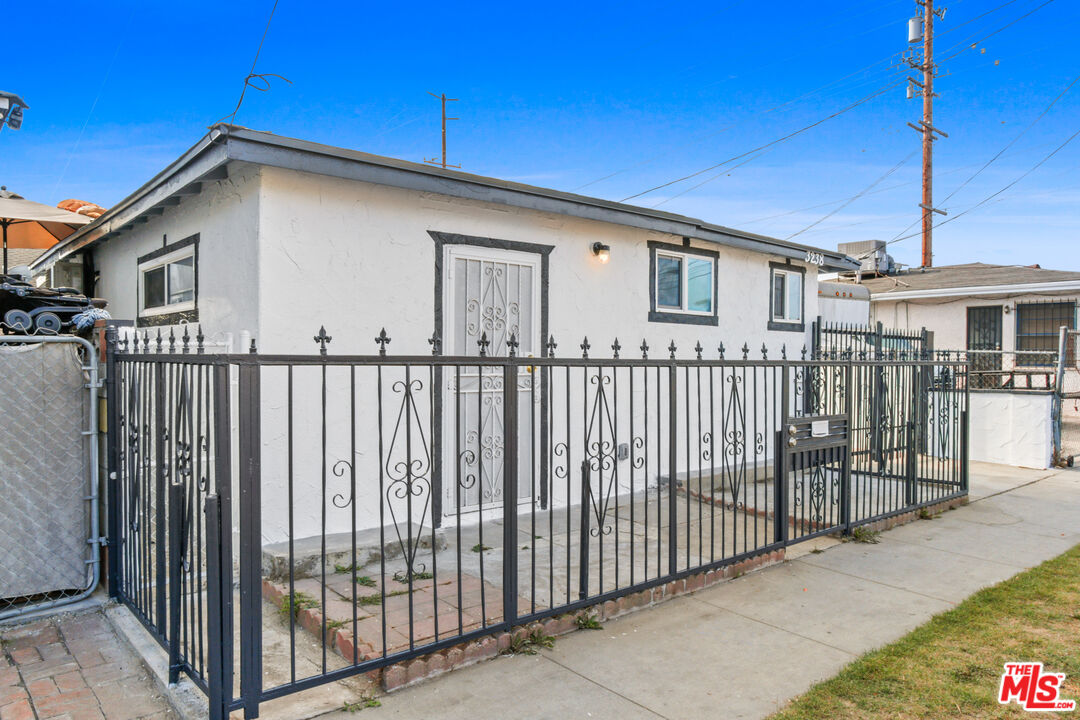 a view of a house with wooden fence