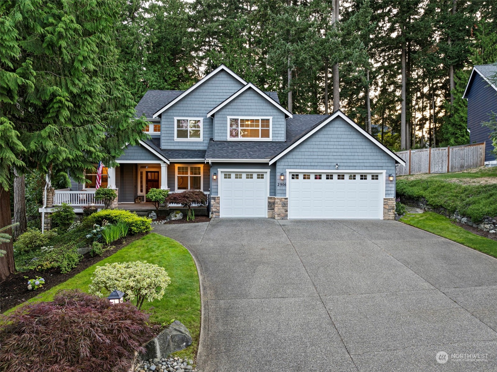 a view of a house with a yard and large trees